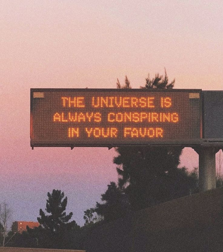 Highway sign reading the universe is always conspiring in your favor